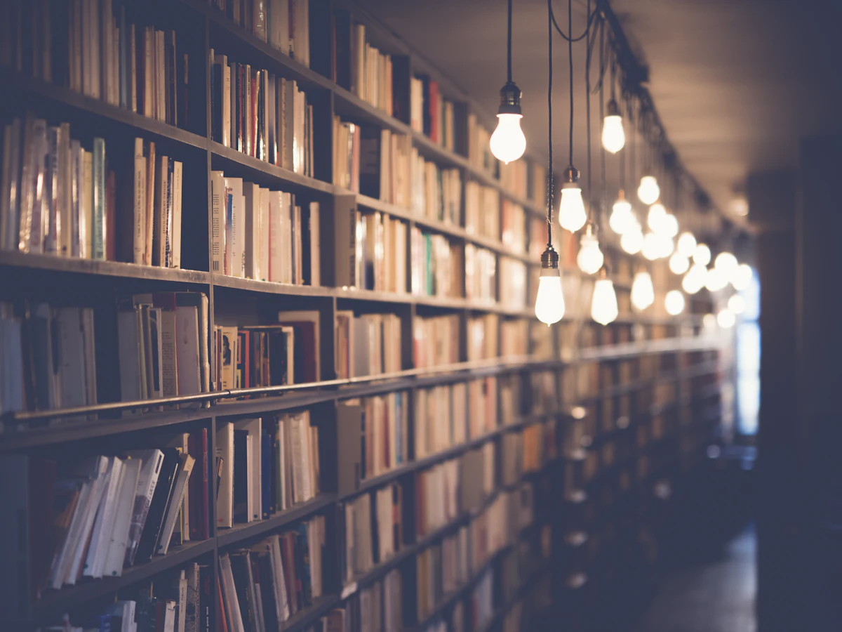 Library shelves lit by warm hanging lamps